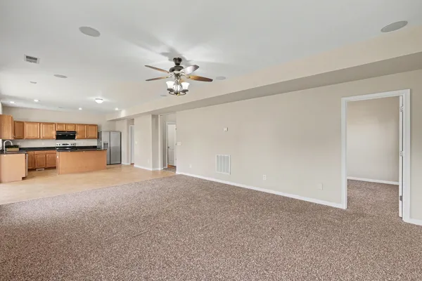 a view of an empty room with a kitchen