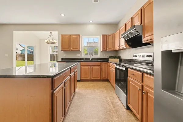 a kitchen with stainless steel appliances granite countertop wooden cabinets a sink and a stove
