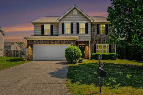 a front view of a house with a yard and garage