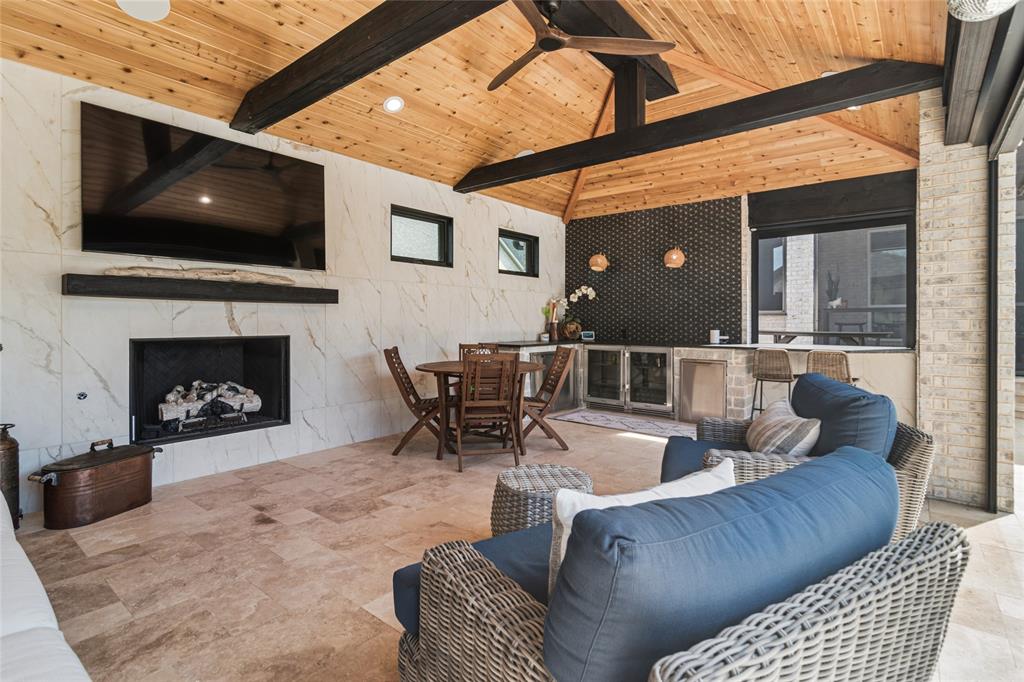 1920 Lotus Court Haslet, TX 76052 - Photo 31 of 40 Inside of the pool house, fireplace, vaulted cedar ceiling, travertine flooring, tiled wall with transom windows. L shaped counter top for serving with counter for bar seating. Custom tile above counter.