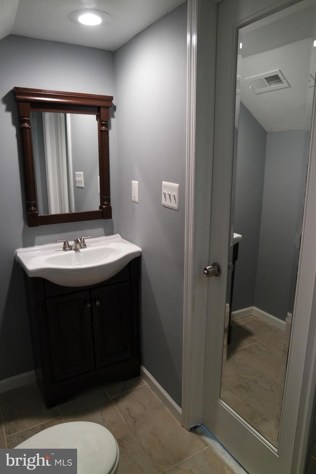 6716 Larkspur Road Morningside, MD 20746 - Photo 15 of 23 a bathroom with a sink a toilet and mirror