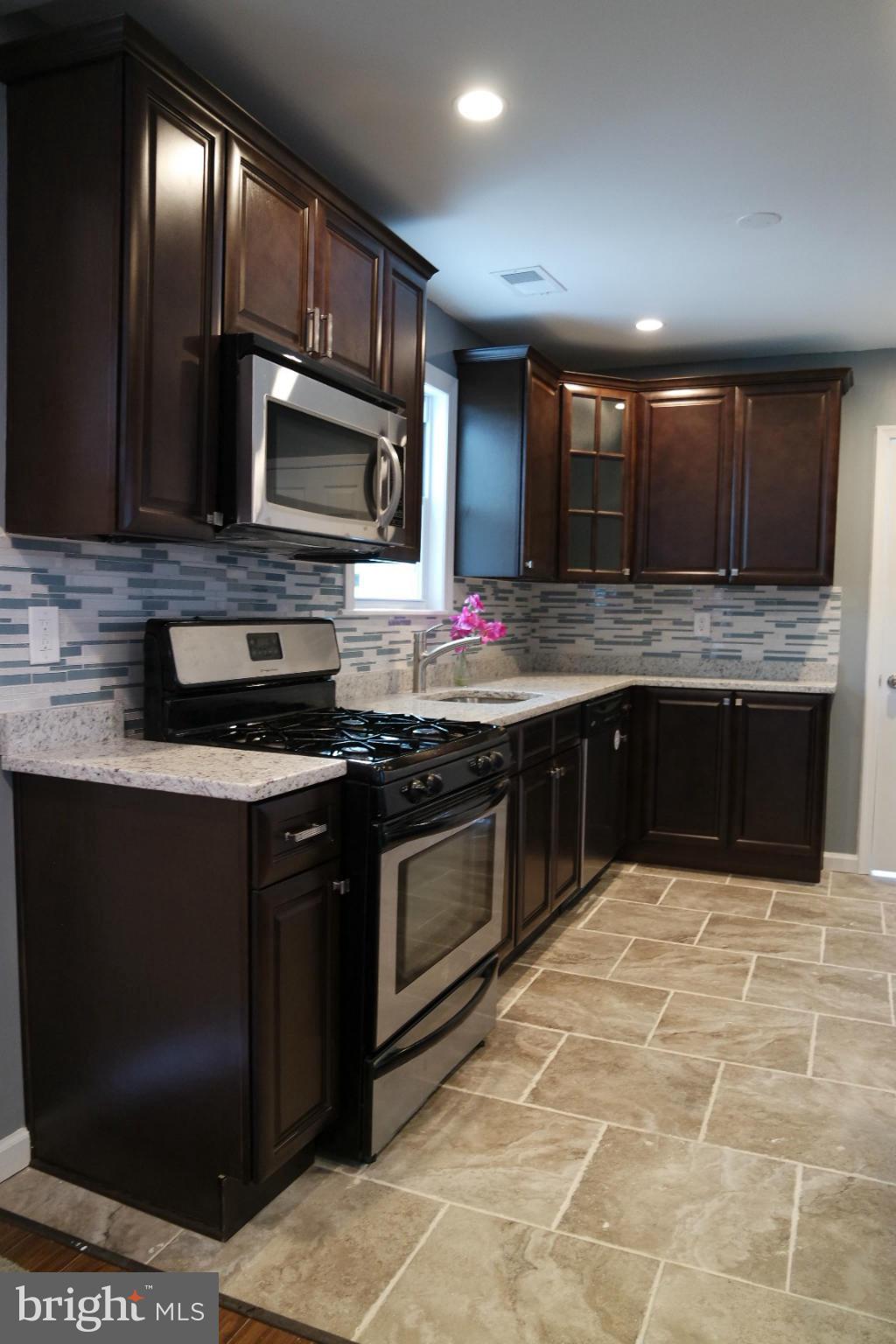 6716 Larkspur Road Morningside, MD 20746 - Photo 3 of 23 a kitchen with stainless steel appliances granite countertop a stove a sink and a microwave