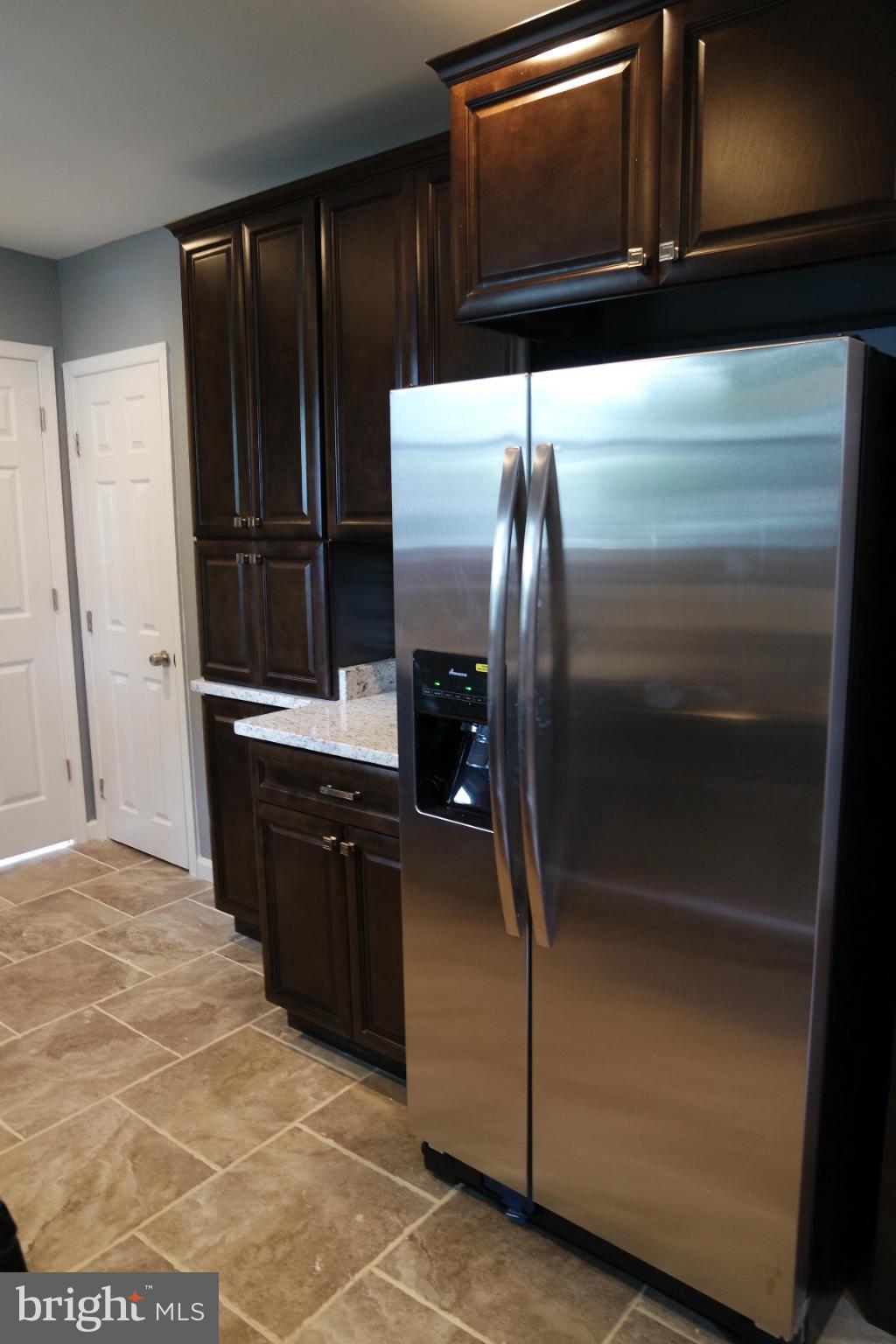 6716 Larkspur Road Morningside, MD 20746 - Photo 4 of 23 a kitchen with granite countertop stainless steel appliances and refrigerator
