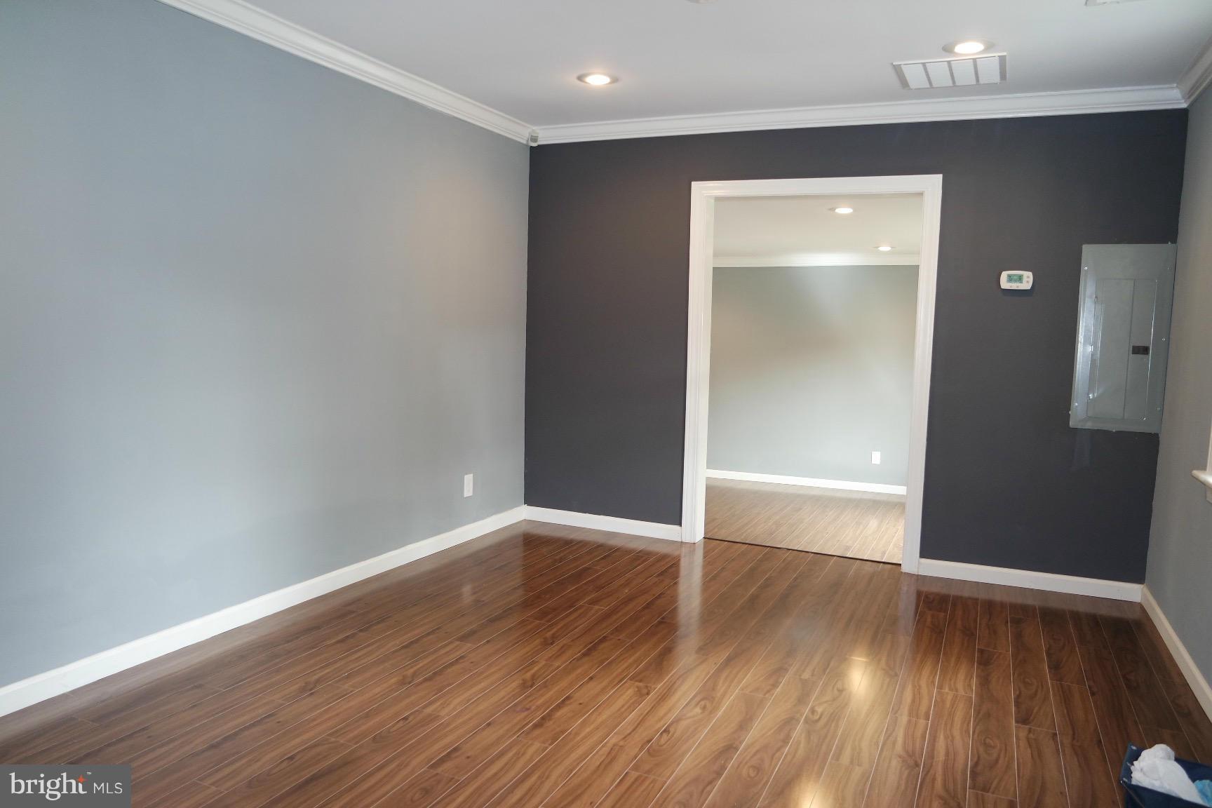 6716 Larkspur Road Morningside, MD 20746 - Photo 5 of 23 a view of an empty room with wooden floor and a window