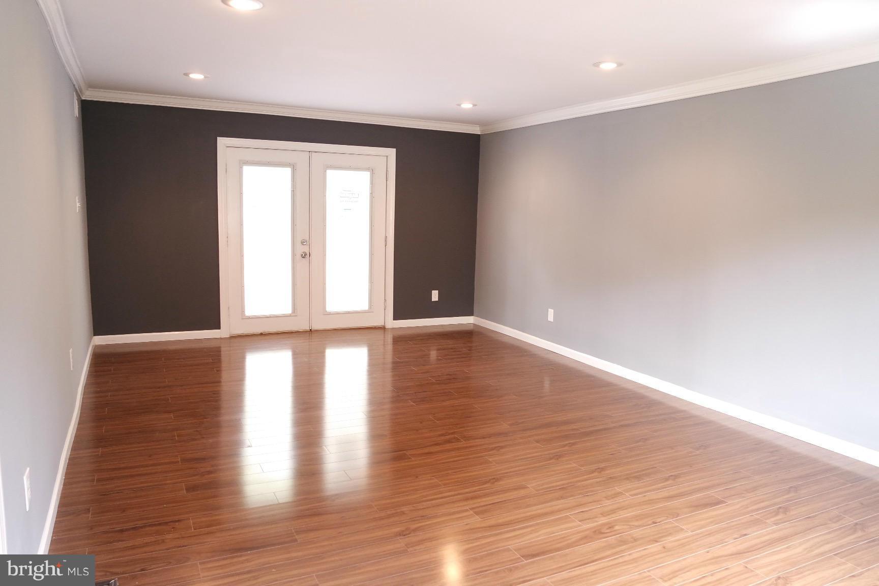6716 Larkspur Road Morningside, MD 20746 - Photo 6 of 23 a view of an empty room with wooden floor and a window