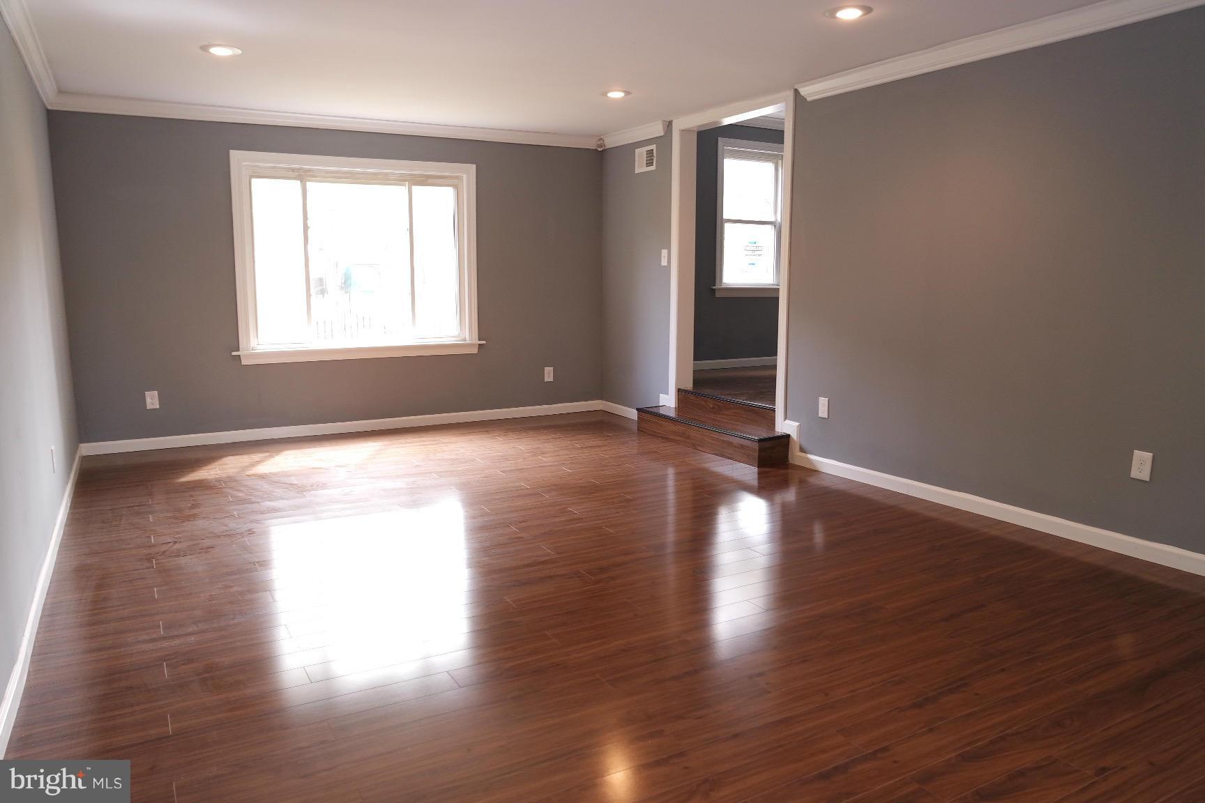 6716 Larkspur Road Morningside, MD 20746 - Photo 7 of 23 a view of an empty room with wooden floor and a window