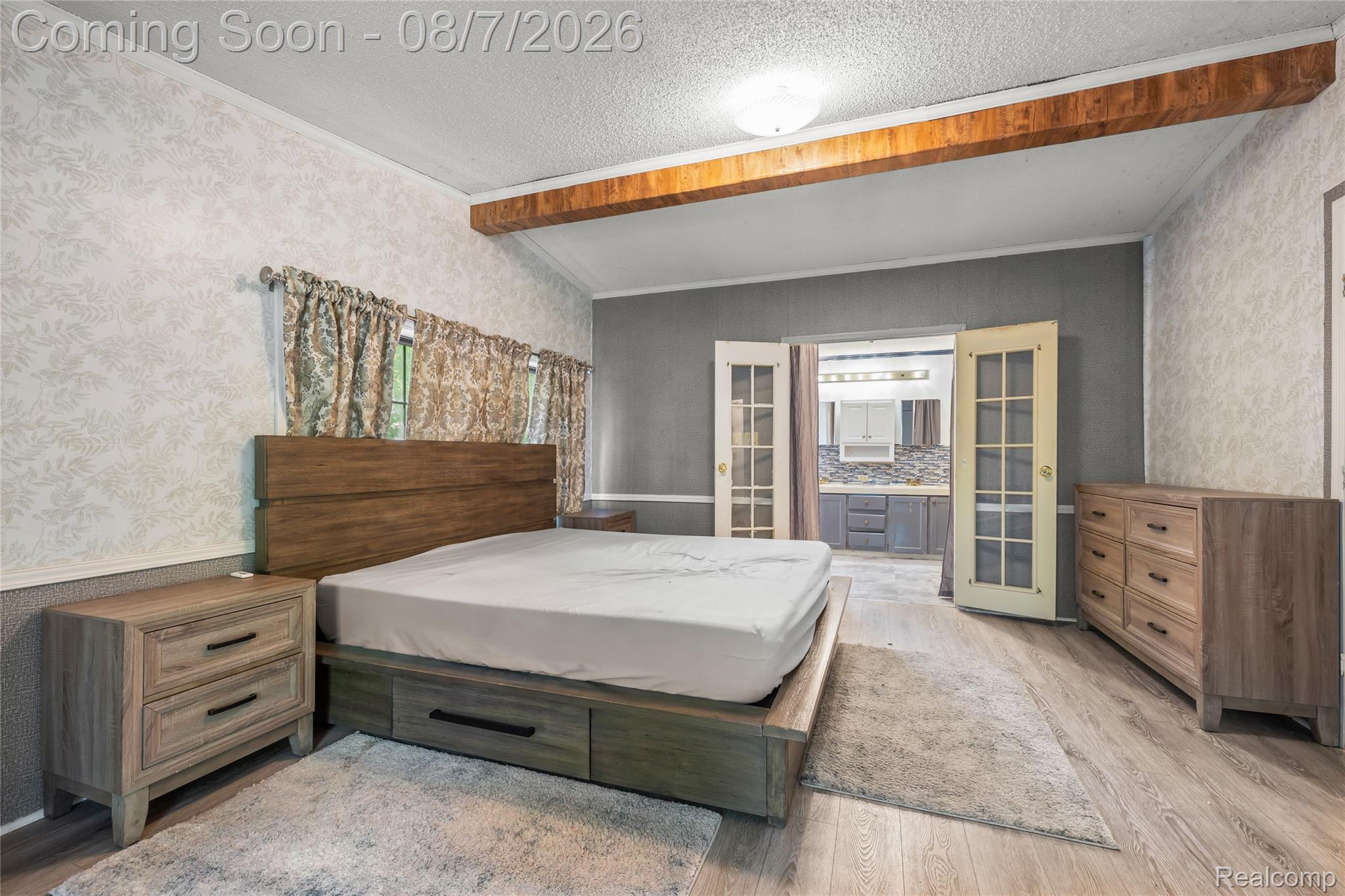 9940 Bunton Road Willis, MI 48191 - Photo 23 of 26 Spacious bedroom featuring wood-finish flooring, exposed ceiling beam accents, and decorative wall treatments