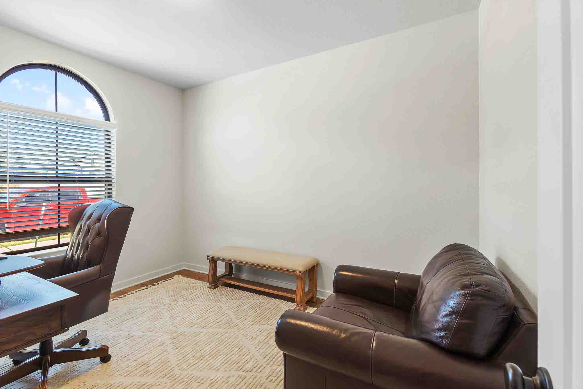 220 Basket Flower Loop Kyle, TX 78640 - Photo 24 of 40 A quiet home office features a gracefully arched window and rich wood trim.