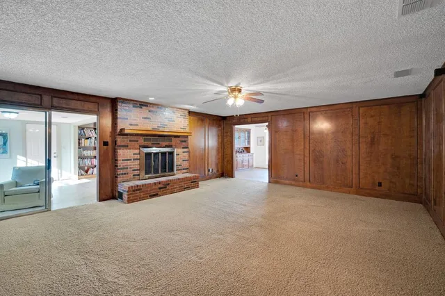 a view of an empty room with a fireplace and a window