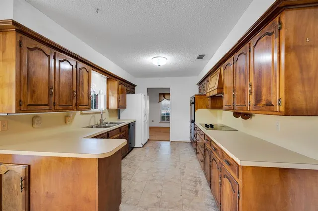 a kitchen with a sink a stove and cabinets