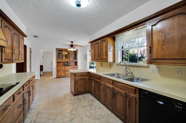 a large kitchen with stainless steel appliances granite countertop a sink counter space and a large window