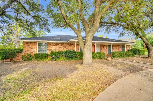 a view of a house with a tree in front of it
