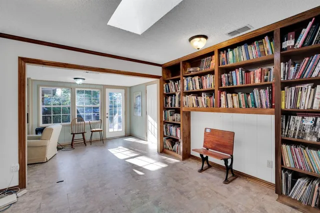 a living room with furniture and a book shelf
