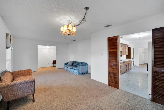 a view of a livingroom with a chandelier furniture and windows