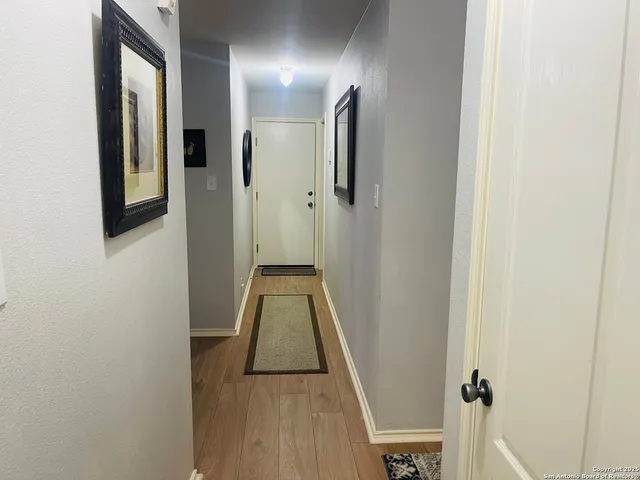 a view of a hallway with wooden floor