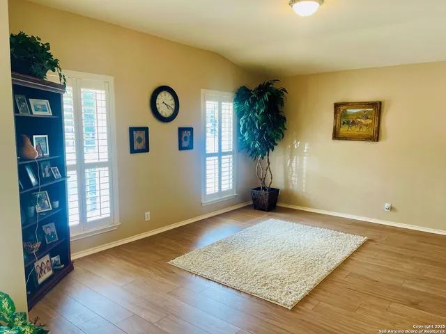 an empty room with window and wooden floor