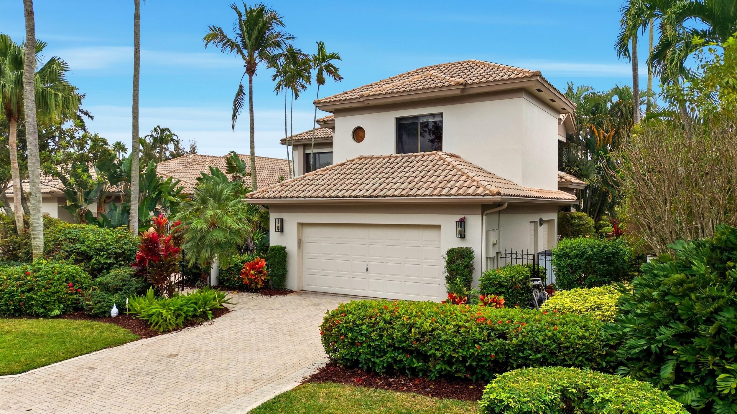2248 Northwest 60th Street Boca Raton, FL 33496 - Photo 3 of 70 a view of a white house with a yard and potted plants