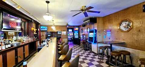 an empty room with wooden floor and a ceiling fan