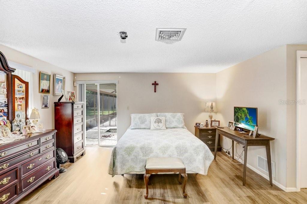 12600 Castleberry Court Bayonet Point, FL 34667 - Photo 33 of 52 a bedroom with a bed and wooden floor