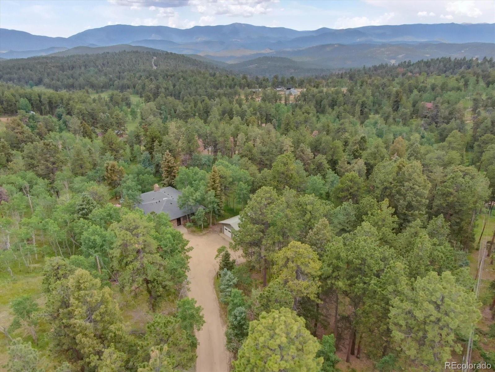 28858 Richmond Hill Road Conifer, CO 80433 - Photo 32 of 39 a view of a lush green hillside and a houses