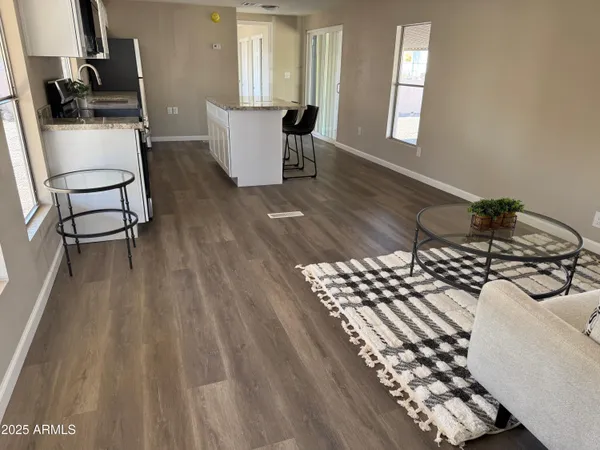 a living room with wooden floor furniture and a window