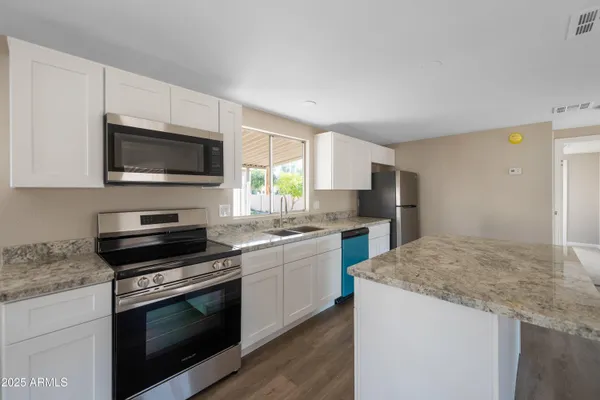 a kitchen with a sink stove and microwave