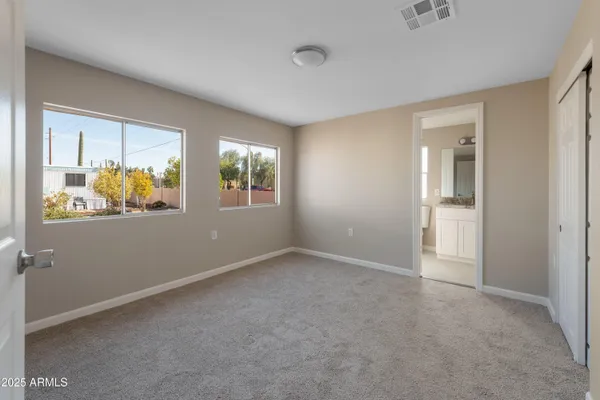 an empty room with windows and closet