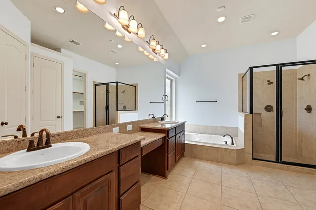 a spacious bathroom with a granite countertop sink a toilet a mirror and shower