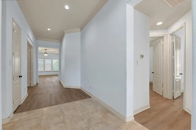 a view of a hallway with wooden floor and windows