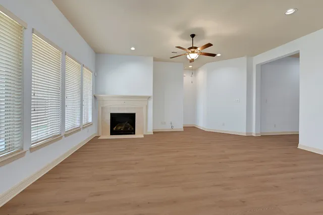 a view of an empty room with a fireplace and a window