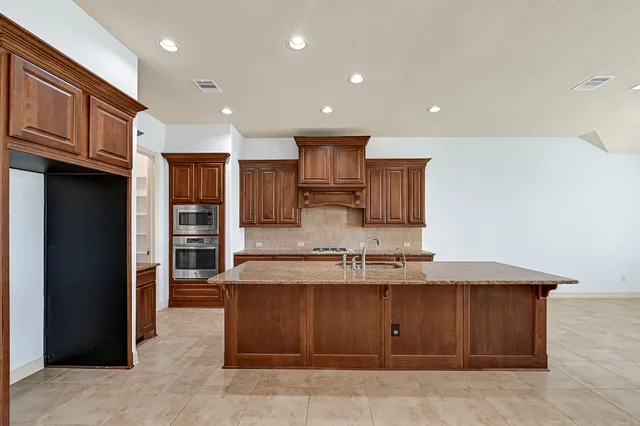 a view of kitchen with stainless steel appliances granite countertop a refrigerator and a sink