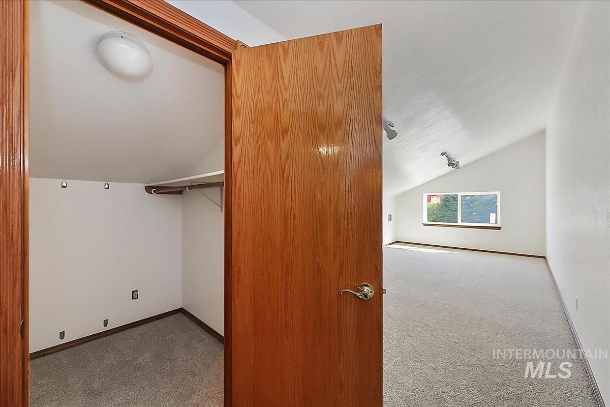 2804 West Sunrise Rim Road Boise, ID 83705 - Photo 28 of 50 Carpeted room featuring a sloped ceiling, track lighting, and a horizontal window