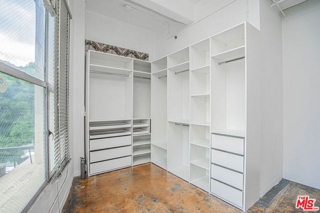 a view of walk in closet with empty racks