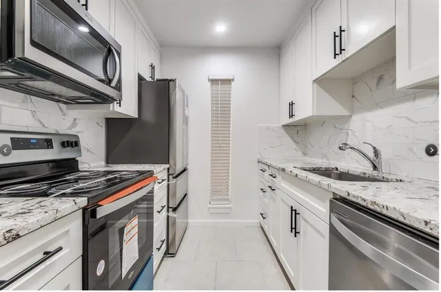 a kitchen with stainless steel appliances granite countertop a stove and a microwave