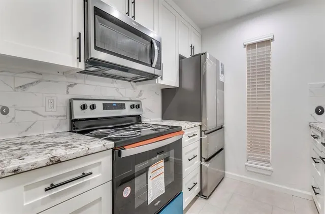 a kitchen with stainless steel appliances granite countertop a stove and a microwave