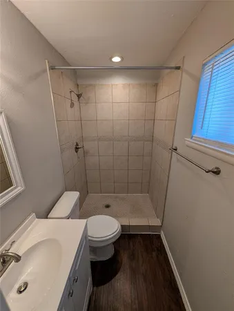 a bathroom with a sink a toilet and shower