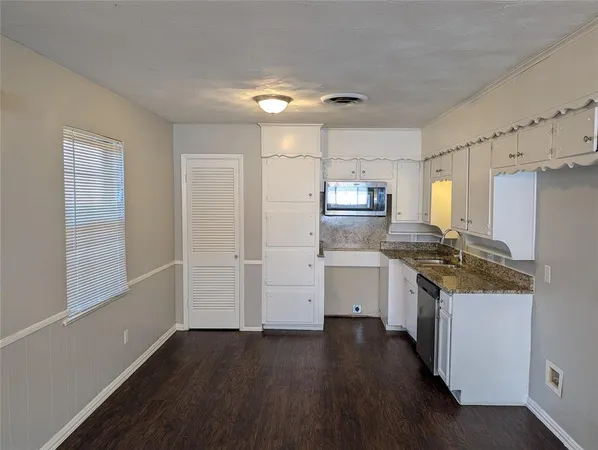 a kitchen with a refrigerator stove and white cabinets
