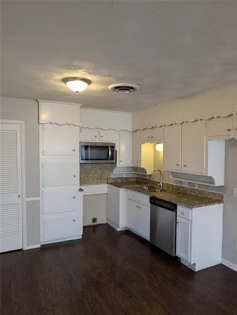 a kitchen with granite countertop white cabinets and white appliances