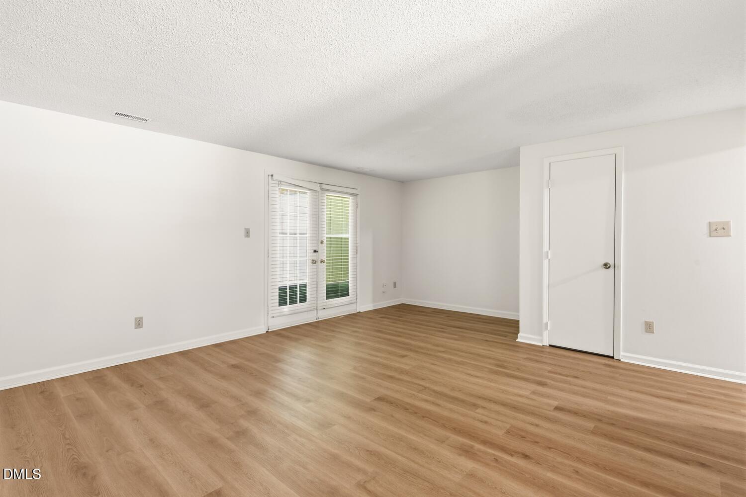 1135 Villa Green Court Raleigh, NC 27612 - Photo 9 of 17 a view of an empty room with wooden floor and windows