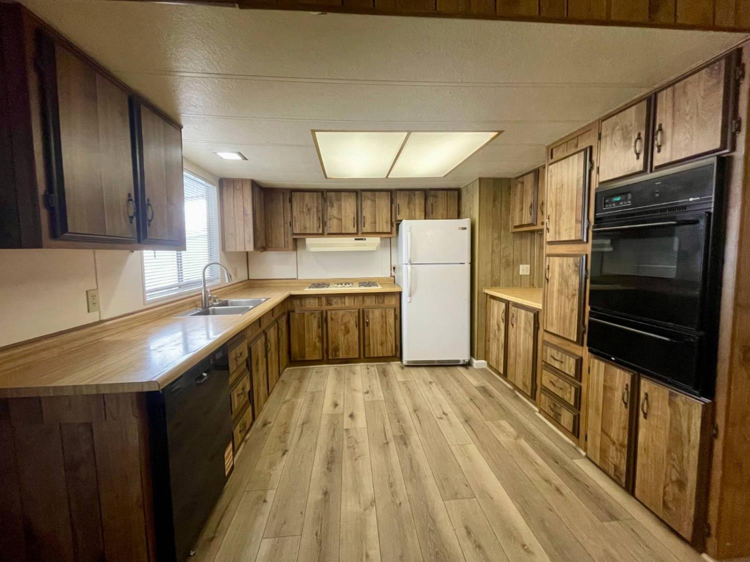 3901 Lake Road, Unit 111 West Sacramento, CA 95691 - Photo 9 of 16 a kitchen with refrigerator cabinets and wooden floor