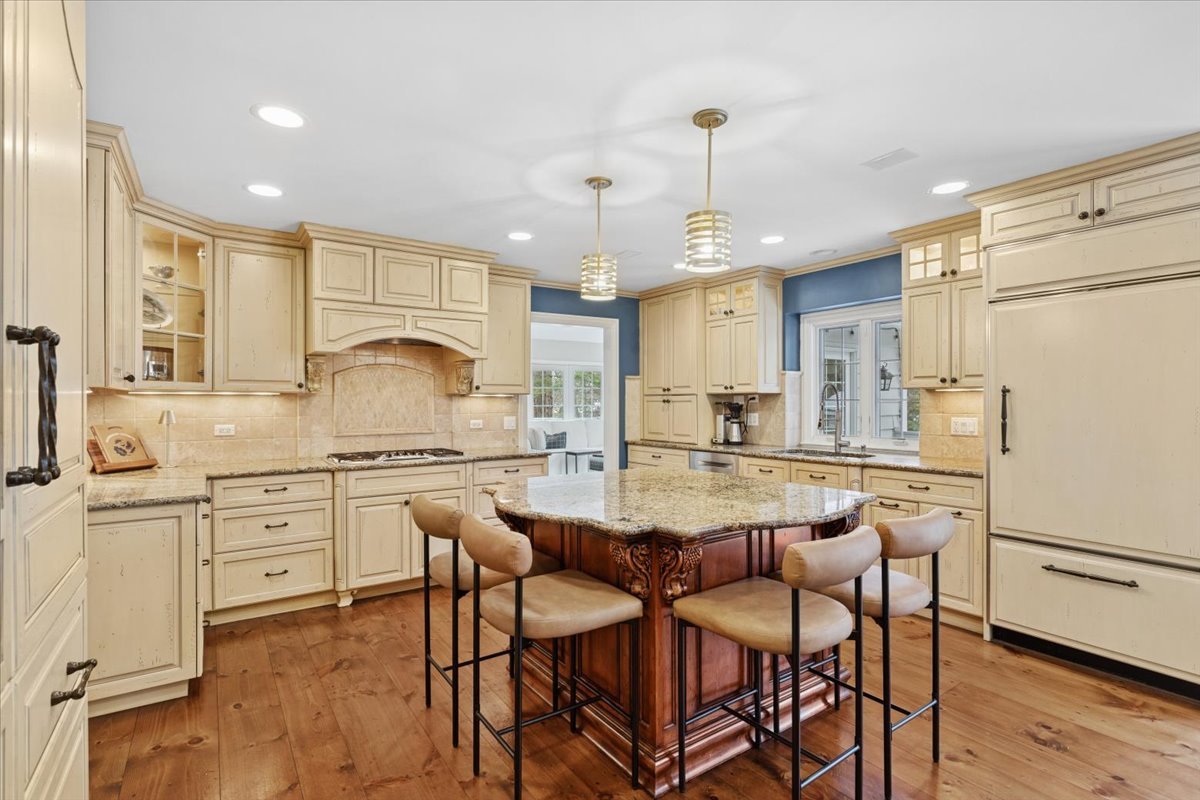 2250 Lisson Road Naperville, IL 60565 - Photo 14 of 53 a kitchen with kitchen island granite countertop wooden cabinets and white appliances