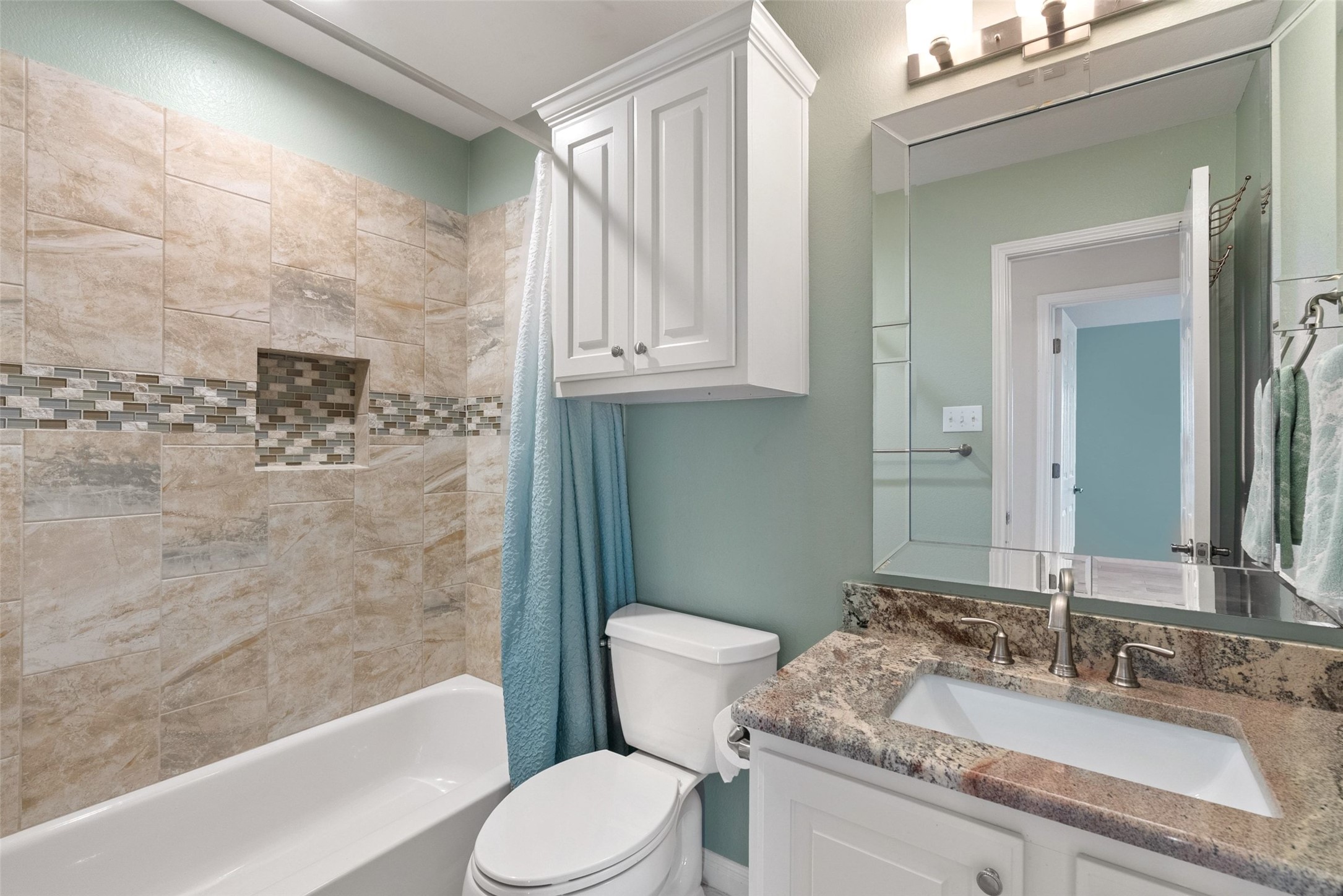 8215 Dark Ridge Cove Austin, TX 78737 - Photo 29 of 40 The upstairs hall guest bathroom features a granite countertop vanity and updated shower surround.