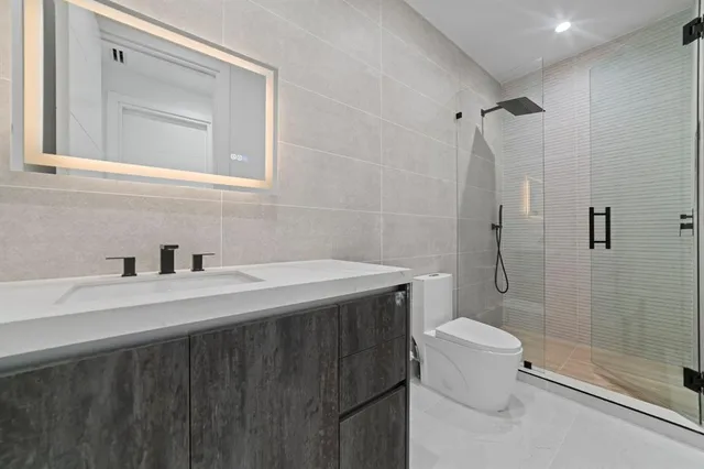 a view of a hallway with entryway and wooden floor