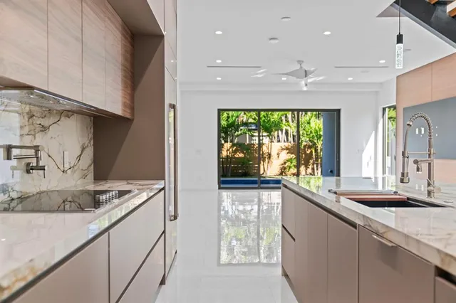 a kitchen with stainless steel appliances granite countertop a sink and a large window
