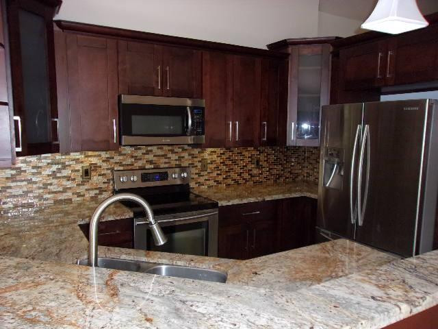 1564 Sunset Way Weston, FL 33327 - Photo 2 of 40 a kitchen with granite countertop a refrigerator stove and microwave