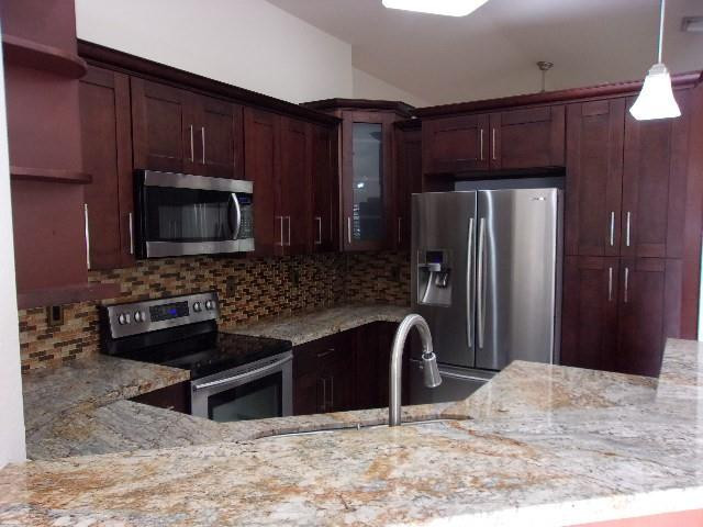 1564 Sunset Way Weston, FL 33327 - Photo 33 of 40 a kitchen with granite countertop wooden cabinets a refrigerator and a sink
