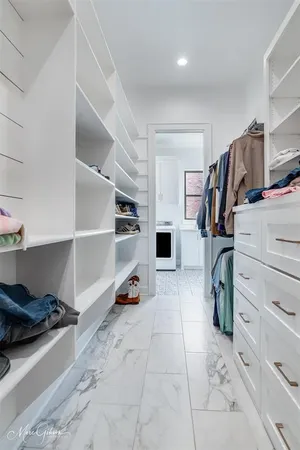 a view of walk in closet with clothes and shoes