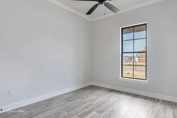an empty room with a window and wooden floor