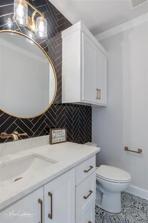 a bathroom with a sink a toilet and a mirror