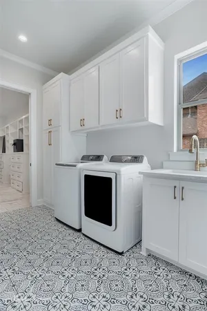 a utility room with stainless steel appliances granite countertop a sink a stove a refrigerator and cabinets